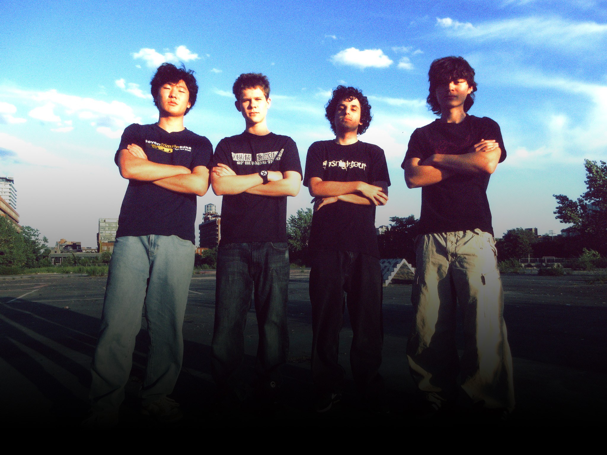 This Is Forgiveness, four members standing on a concrete lot under an open sky
